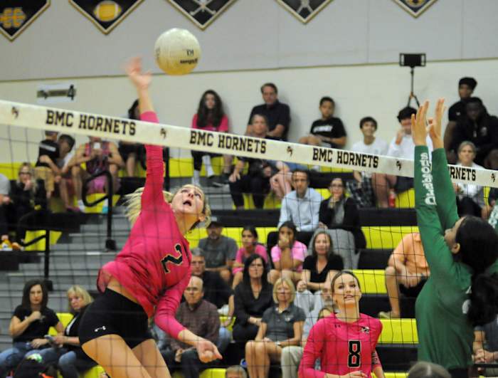 Bishop Moore's Leah McDonald (2) goes for a kill against the block of Lake Placid's Chloe Mendez while Bishop Moore's Jaide Wirth (8) provides backup. McDonald had seven kills and two blocks.